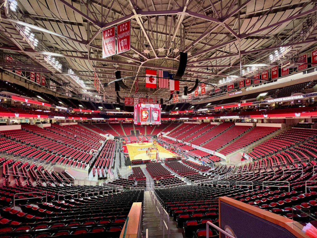 An empty basketball arena with the court set up before a college game