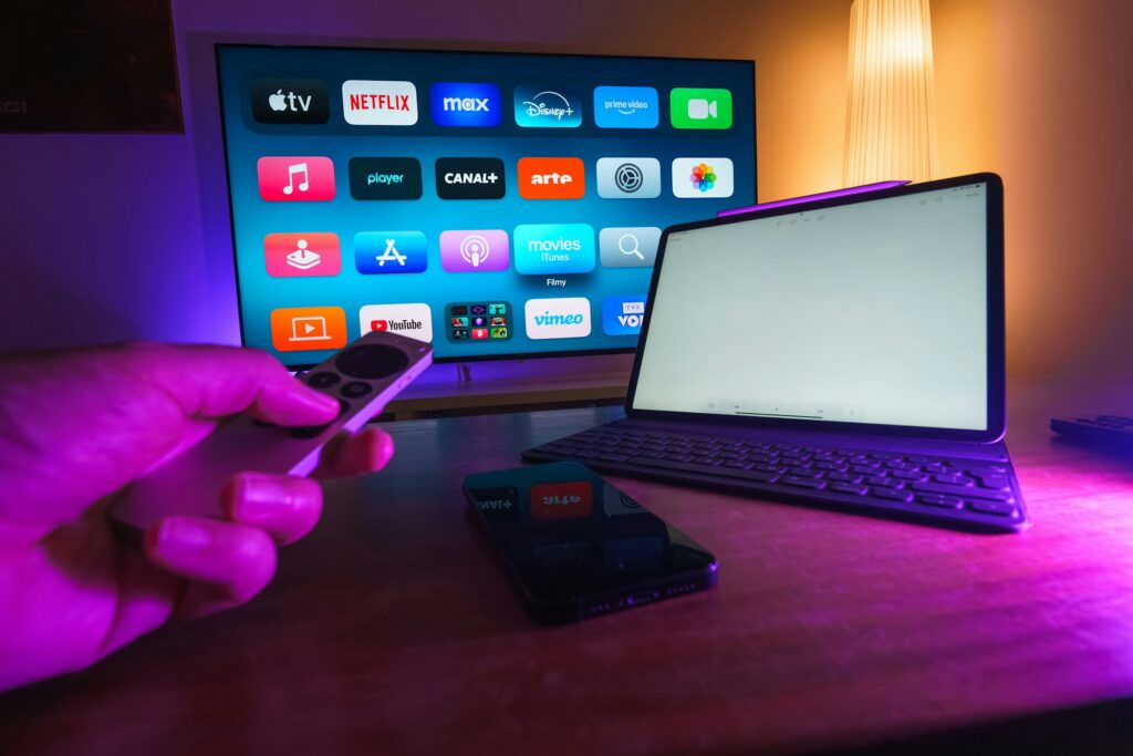A person holding a remote control in front of a television